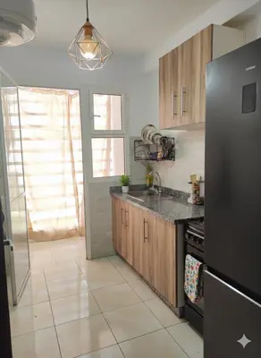 a kitchen with a black refrigerator and a sink at appartement familial a 5min de l'hôpital Mohamed 6 in Bouskoura