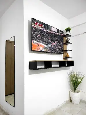 a television on a wall in a living room at appartement familial a 5min de l'hôpital Mohamed 6 in Bouskoura