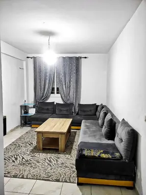 a living room with a couch and a coffee table at appartement familial a 5min de l'hôpital Mohamed 6 in Bouskoura