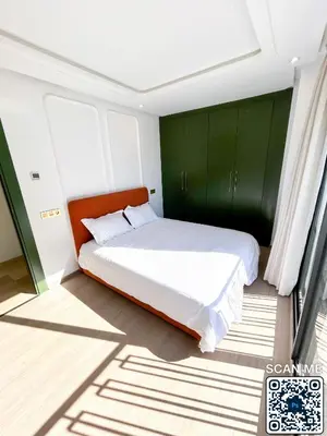a bedroom with a large bed with green cabinets at residence resowod in Maarif