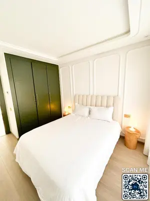 a bedroom with a large white bed with green cabinets at residence resowod in Maarif