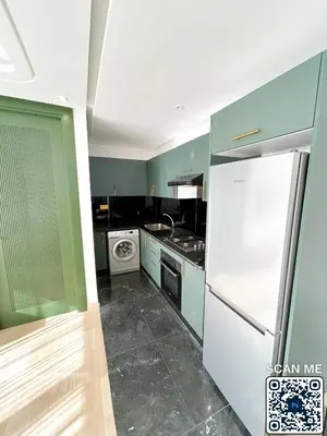 a kitchen with green cabinets and a white refrigerator at residence resowod in Maarif