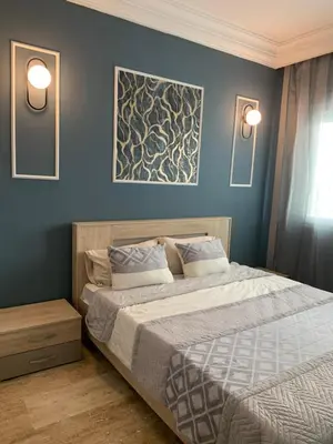 a bedroom with a large bed with blue walls at Casablanca Stay in Casablanca