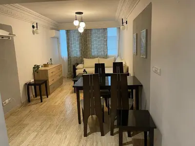 a dining room and living room with a table and chairs at Casablanca Stay in Casablanca