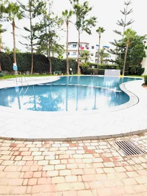 an empty swimming pool in a park with trees at Venezia apartment with 2 Large Bedrooms 3 Beds in Mohammedia