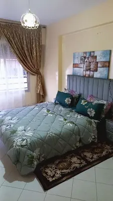 a bedroom with a large bed with a green comforter at IDY HOME's in Casablanca