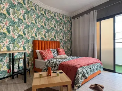 a bedroom with a bed and a table at Elegant studio with large terrace in Rabat