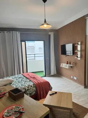 a hotel room with a bed and a flat screen tv at Elegant studio with large terrace in Rabat