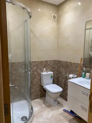 a bathroom with a shower and a toilet and a sink at 2 bedroom apartment in a secured residence, minutes to beach in Bouznika