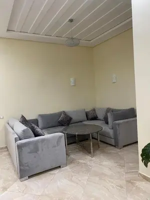 a living room with a couch and a table at 2 bedroom apartment in a secured residence, minutes to beach in Bouznika