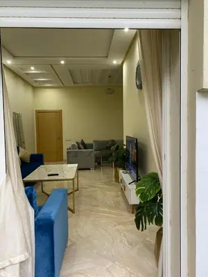 a living room with a couch and a table at 2 bedroom apartment in a secured residence, minutes to beach in Bouznika