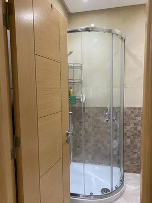 a shower with a glass door in a bathroom at 2 bedroom apartment in a secured residence, minutes to beach in Bouznika