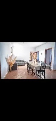 a living room with a dining room table and chairs at Appartement spacieux à 15 minutes du stade Moulay Abdellah in Temara
