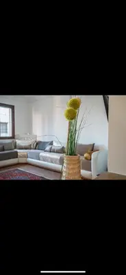 a living room with couches and a vase with flowers at Appartement spacieux à 15 minutes du stade Moulay Abdellah in Temara