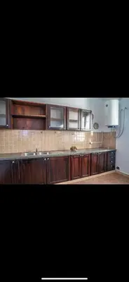 a kitchen with wooden cabinets and a counter top at Appartement spacieux à 15 minutes du stade Moulay Abdellah in Temara