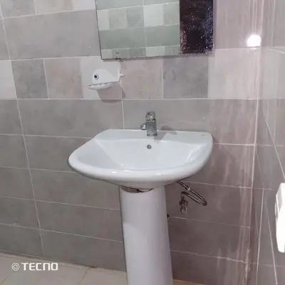a bathroom with a white sink and a mirror at Hébergement en lit dans chambre et salle de bain partagées pour Hommes in Rabat