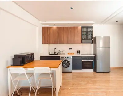 a kitchen with a wooden table and a refrigerator at residence living housse in Casablanca