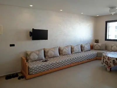 a couch in a living room with a flat screen tv at A beautiful apartment for you in Rabat