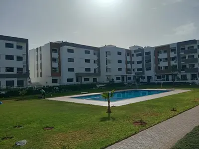 a large apartment building with a swimming pool in a park at A beautiful apartment for you in Rabat