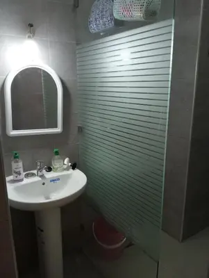a bathroom with a sink and a shower with a mirror at A beautiful apartment for you in Rabat