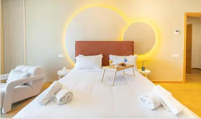 a bedroom with a large white bed and a chair at Panoramic sea view high speed wi-fi central in Casablanca