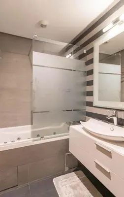 a bathroom with a sink and a tub and a mirror at Panoramic sea view high speed wi-fi central in Casablanca