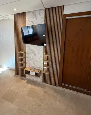 a television hanging on a wall in a lobby at La garonne in Casablanca