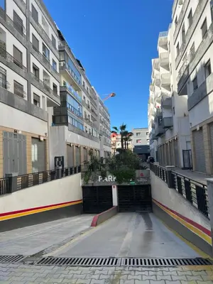 an empty street in a city with tall buildings at La garonne in Casablanca