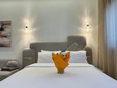a vase sitting on top of a white bed at Premium Studio near Agdal Train Station in Rabat