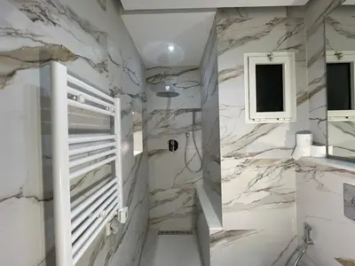 a bathroom with white marble walls and a window at Premium Studio near Agdal Train Station in Rabat