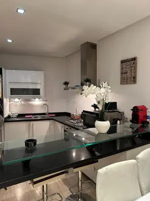 a kitchen with a counter with a vase of flowers on it at 9 Rue d'Alger Casablanca in Casablanca