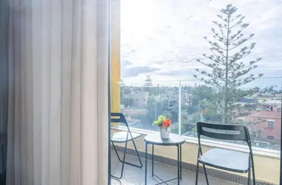 a table and chairs in front of a window with a tree at Super Summit Apartments Le Phenix in Casablanca