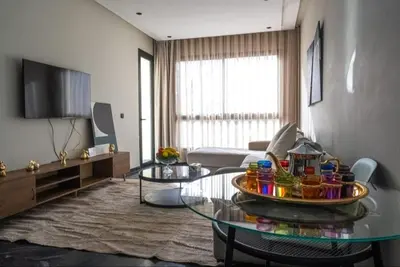 a living room with a glass table and a couch at Super Summit Apartments Le Phenix in Casablanca