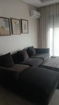 a living room with a couch and a window at Relaxing Studio Stay with Pool, Balcony & Smart TV in Aïn Harrouda