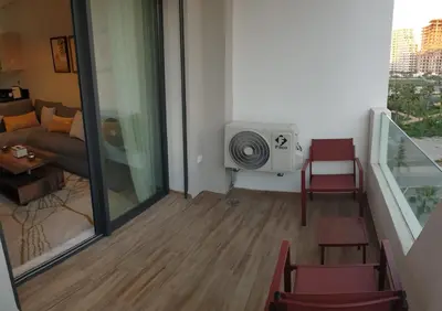 a living room with a couch and a tv in a room at Relaxing Studio Stay with Pool, Balcony & Smart TV in Aïn Harrouda