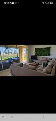 a living room with two couches and a table at Appartement en front de mer in Sidi el Haj Bou Derbala
