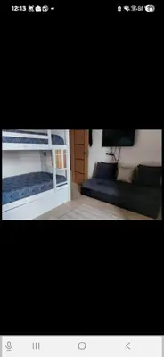 a picture of a bedroom with a bed and a tv at Appartement en front de mer in Sidi el Haj Bou Derbala