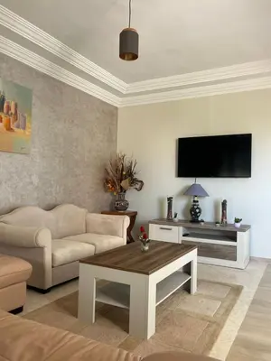 a living room with a couch and a flat screen tv at Appartement lumineux en plein coeur de harhoura in El Harhoura