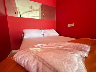 a red room with a bed and a mirror at Central 80s designer Flat in Casablanca