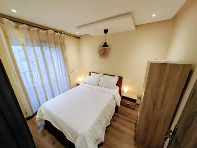 a bedroom with a large white bed and a window at Beachfront View Appartement in Mohammedia