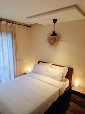 a bedroom with a bed with white sheets and a window at Beachfront View Appartement in Mohammedia