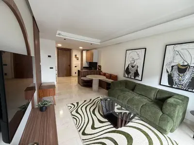 a living room with a green couch and a rug at Charming 1-bedroom apartment, Casablanca Finance City in Casablanca
