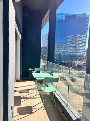 a balcony with a table and chairs and a large window at Charming 1-bedroom apartment, Casablanca Finance City in Casablanca