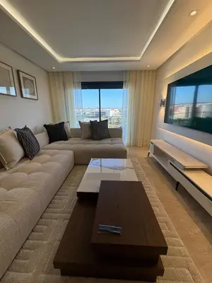 a living room with a couch and a flat screen tv at Agdal Gare View Apartment in Rabat