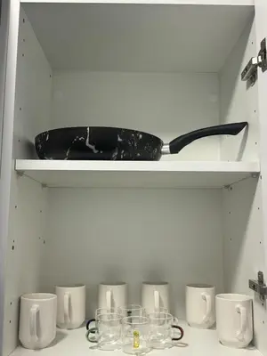 a shelf with cups and a pan on it at Agdal Gare View Apartment in Rabat