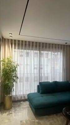 a living room with a blue couch in front of a window at Studio à louer in Casablanca