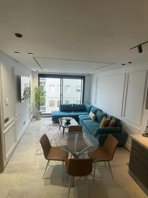 a living room with a blue couch and chairs at Studio à louer in Casablanca