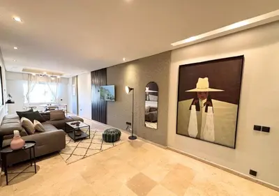 a living room with a large painting of a woman wearing a hat at Grand Studio Moderne au Centre, Parking Privé in Casablanca