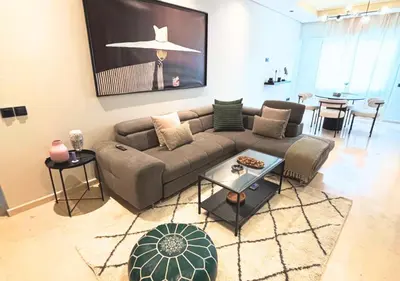 a living room with a couch and a table at Grand Studio Moderne au Centre, Parking Privé in Casablanca