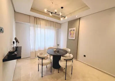 a dining room with a table and some chairs at Grand Studio Moderne au Centre, Parking Privé in Casablanca